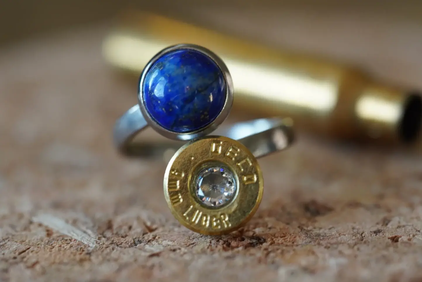 Handgemachter Schmuck Ring aus einer 9mm Patronen Hülse die bei der Jagd oder beim Schießsport verwendet wurde. Versetzt mit einem Zirkon und kombiniert mit dem Edelstein Lapislazuli. Handgefertigt in Österreich