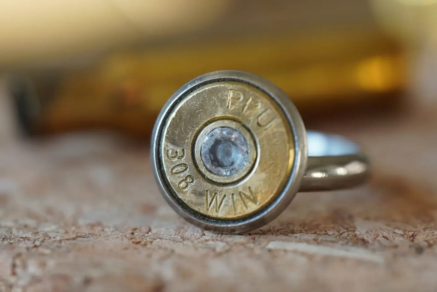 Handgefertigter Schmuck Ring in gold und silber Farbe mit Zirkon. Goldige Scheibe einer Norma Patrone. 