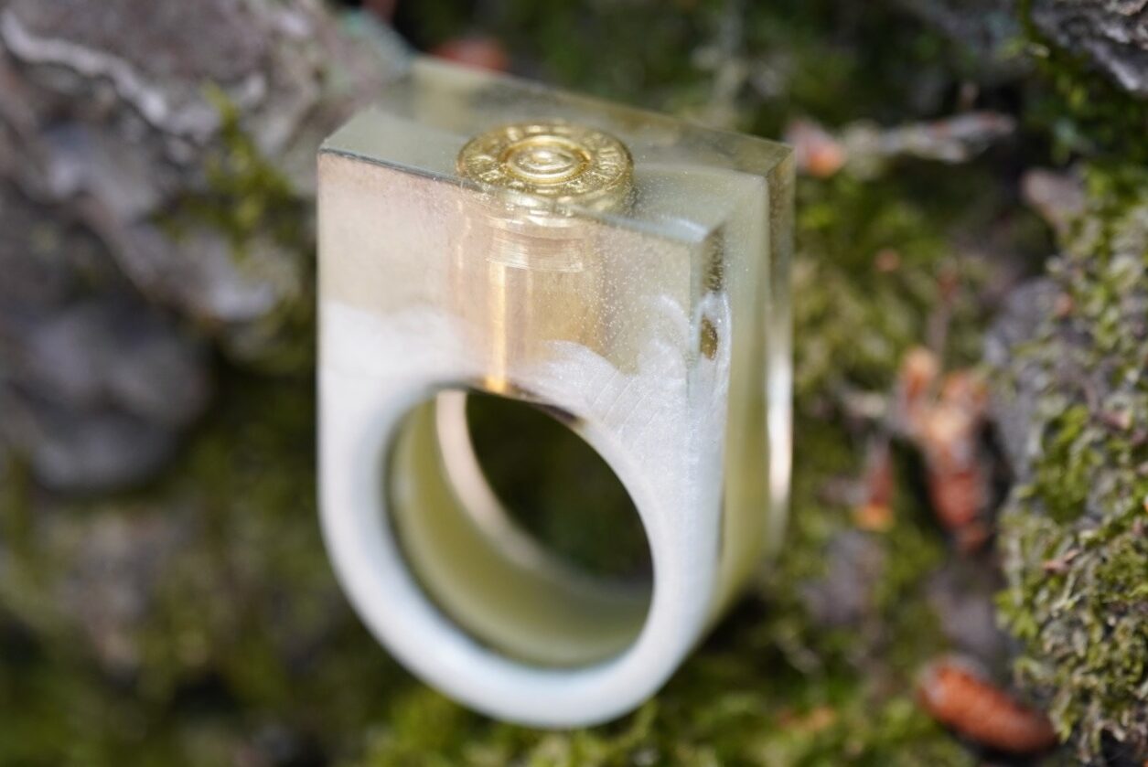 Handgemachter Ring in großem, auffälligem Design. Gegossen eine 9mm Patrone, mit grünen und weißen Farbakzenten. Ein ausgefallener Eye Catcher Ring.